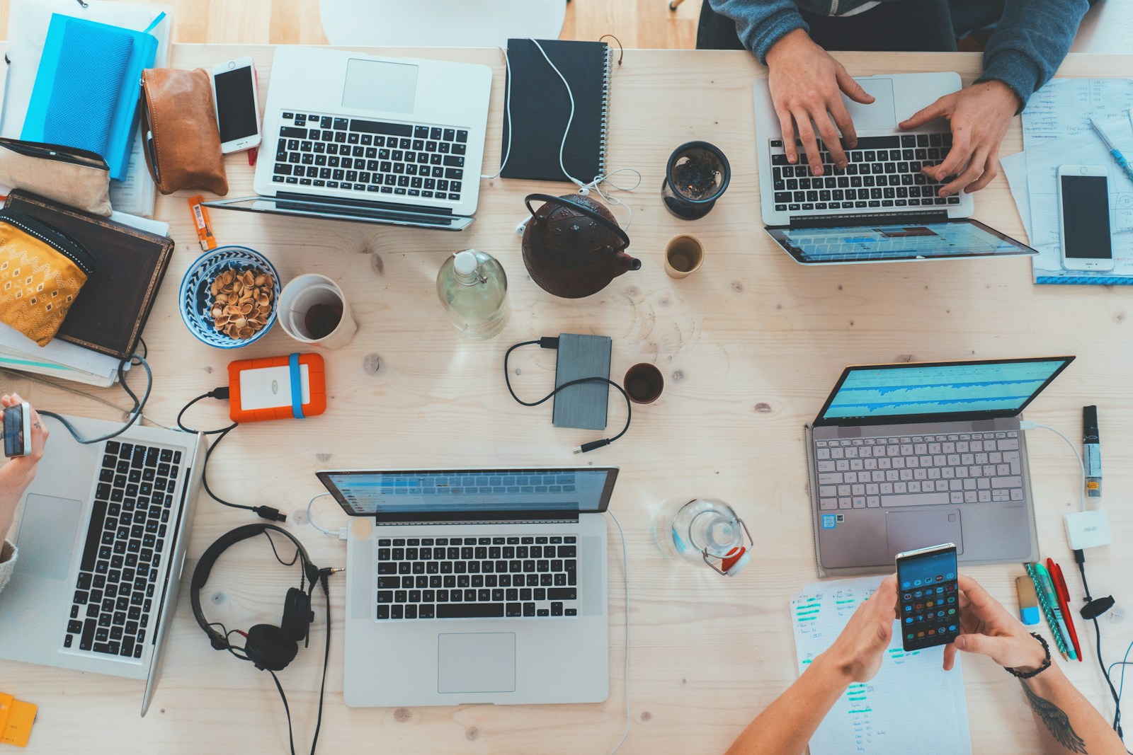 Team aan het werk met laptops en smartphones — zakelijke mobiele abonnementen en databundels controleren