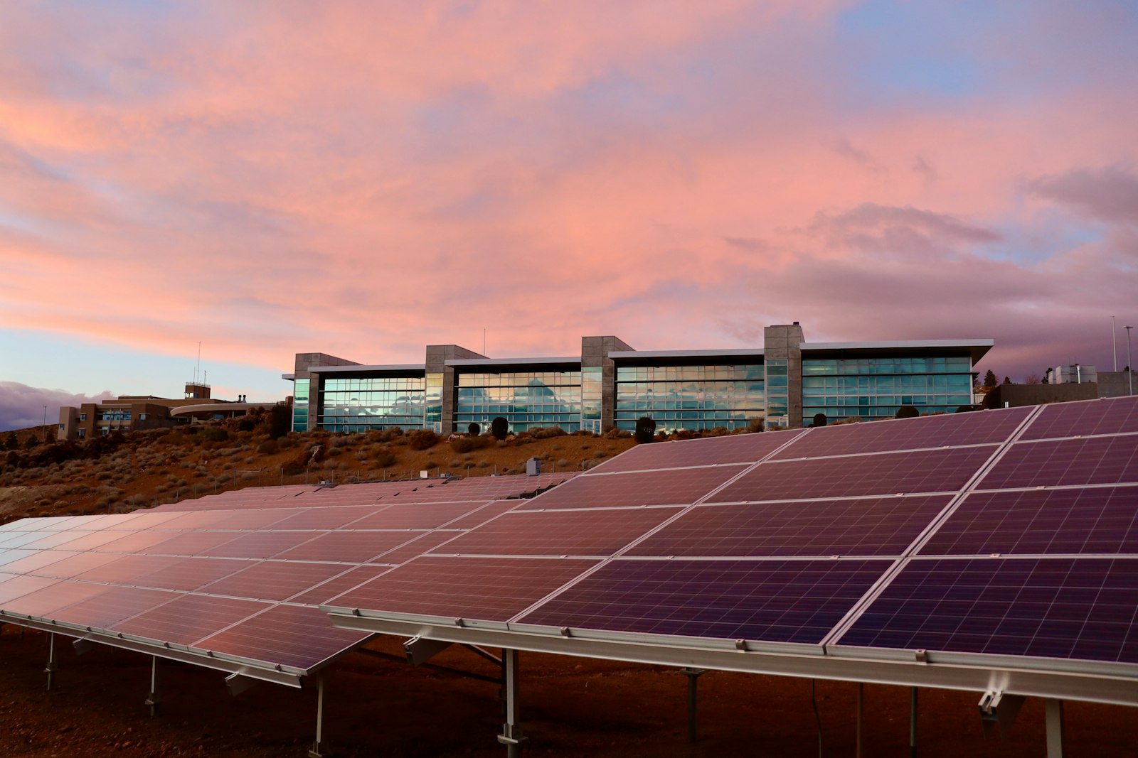Zonnepanelen bij een gebouw in avondlicht — zonnestroom delen met familie of buren